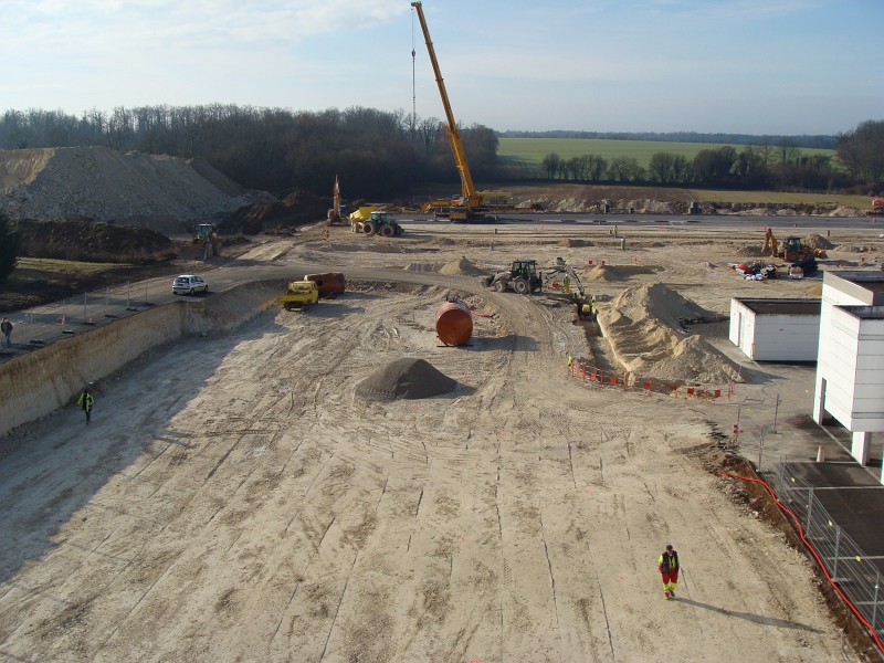 DSC00140.JPG - Emplacement Future Aile Est - Terrassement en cours de finalisation (compactage du sol). Au loin  : grue pour mise en place des cuves de rétention eaux pluviales.